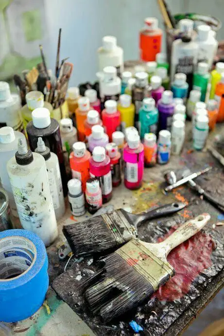 Acrylic paint bottles and brushes on the artist's work table